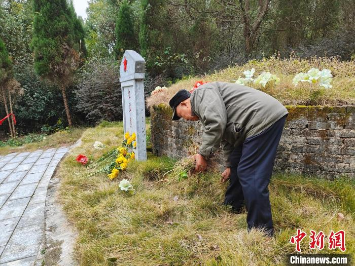 蒋石林为红军烈士墓除草。　杨宗盛 摄.jpg